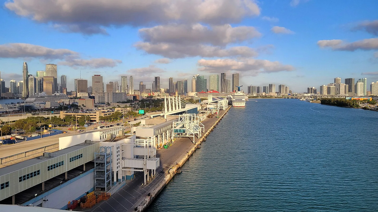 PortMiami, real-world photo: PortMiami's cruise terminals and main channel with the downtown skyline, 2024